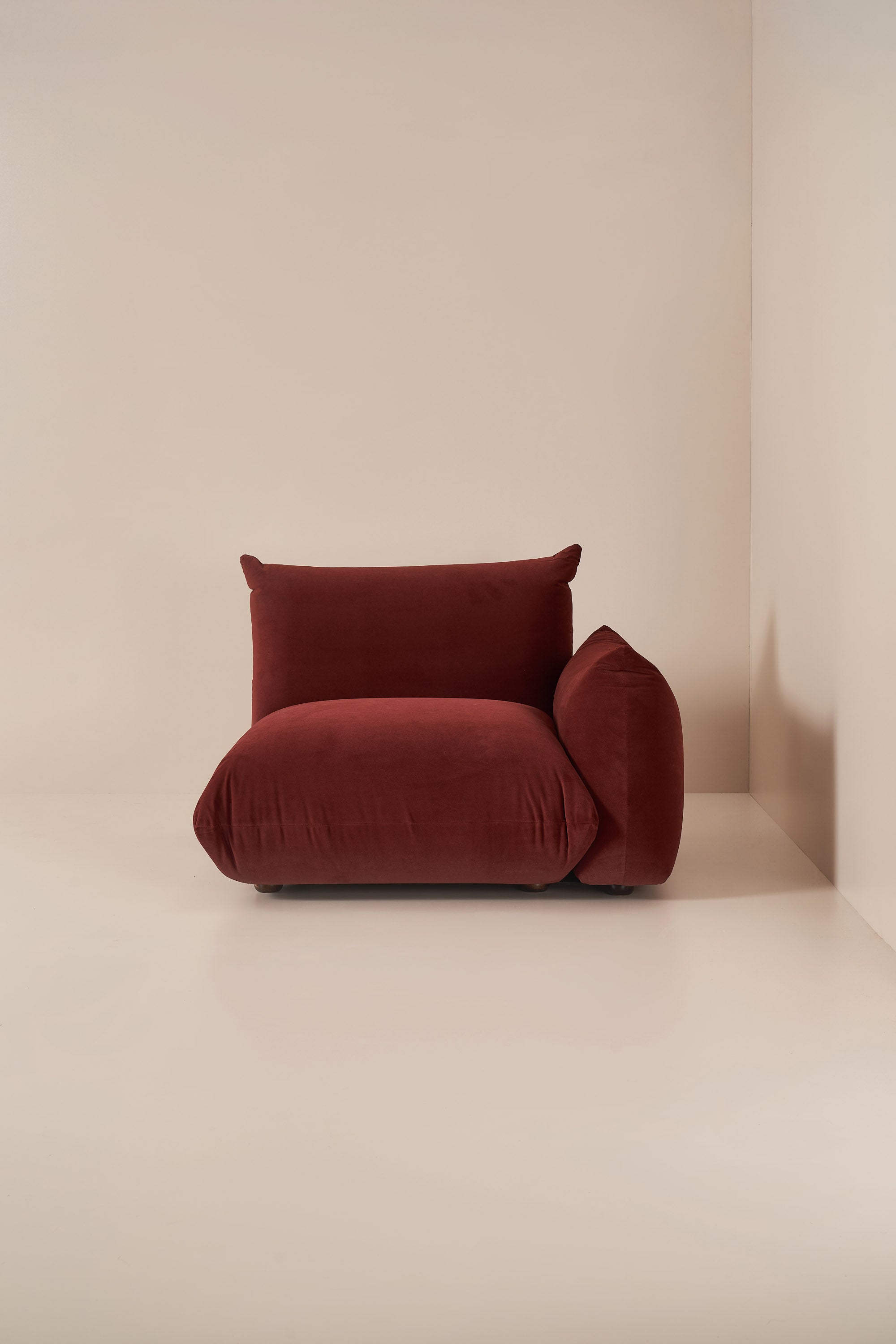 Red armchair against a beige wall