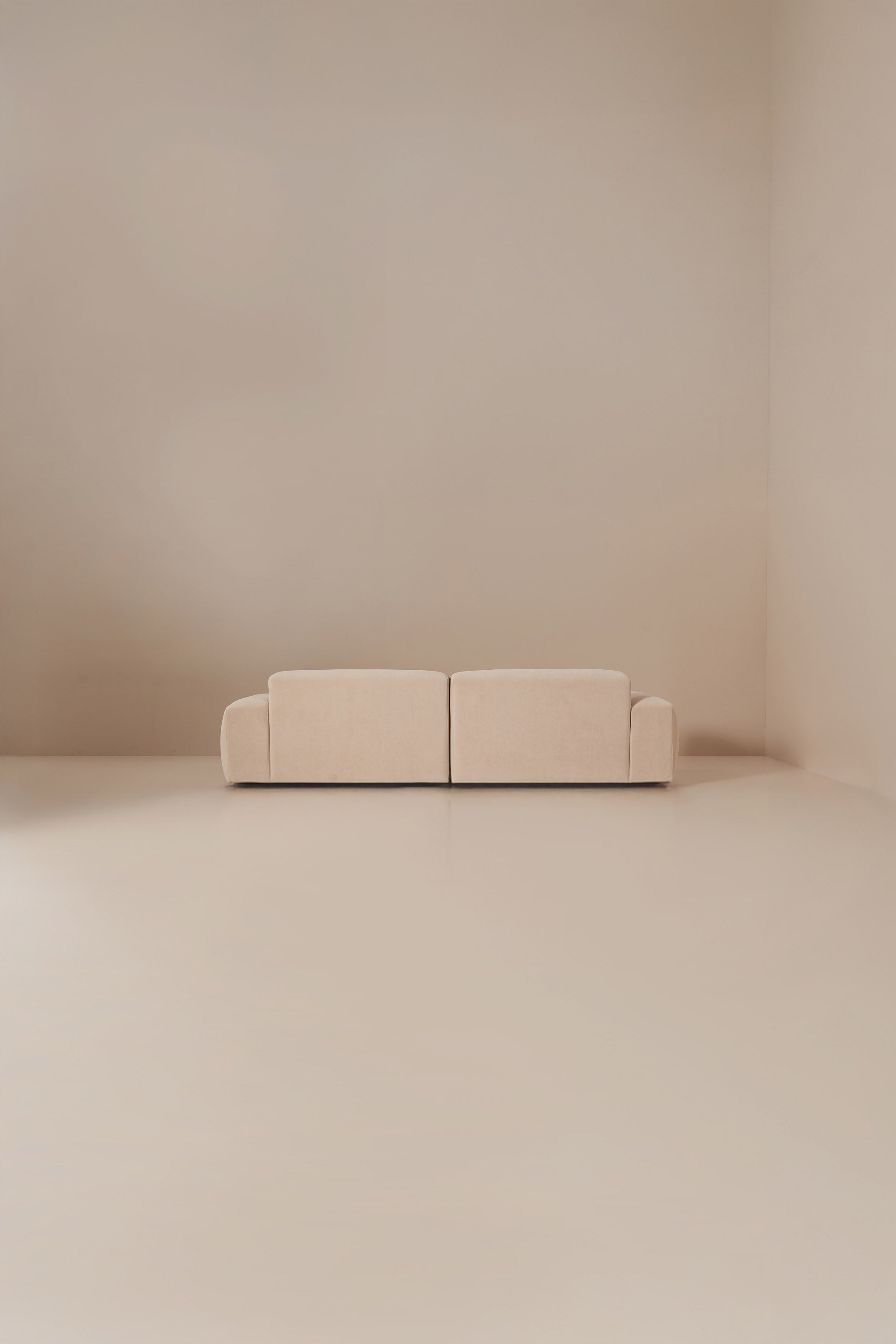Beige sofa in a minimalistic room with beige walls and floor