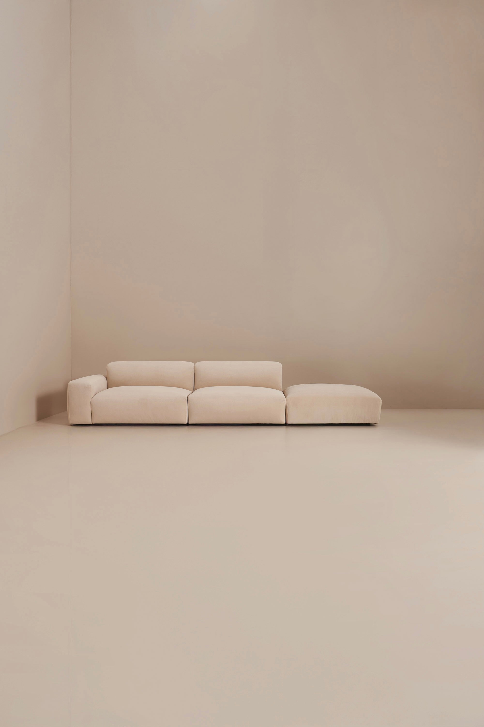 Beige sofa in a minimalistic room with beige walls and floor
