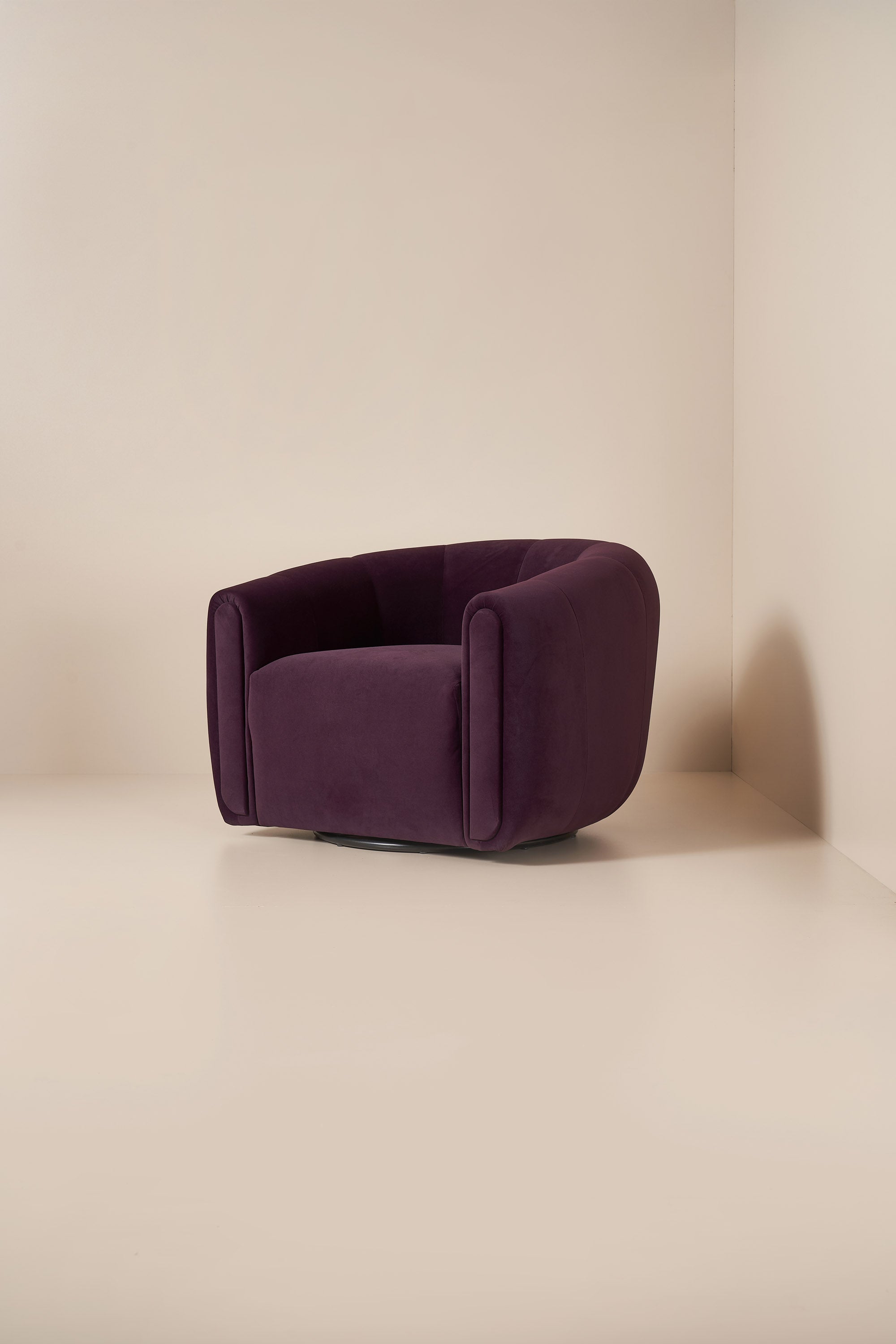 Purple armchair against a beige wall