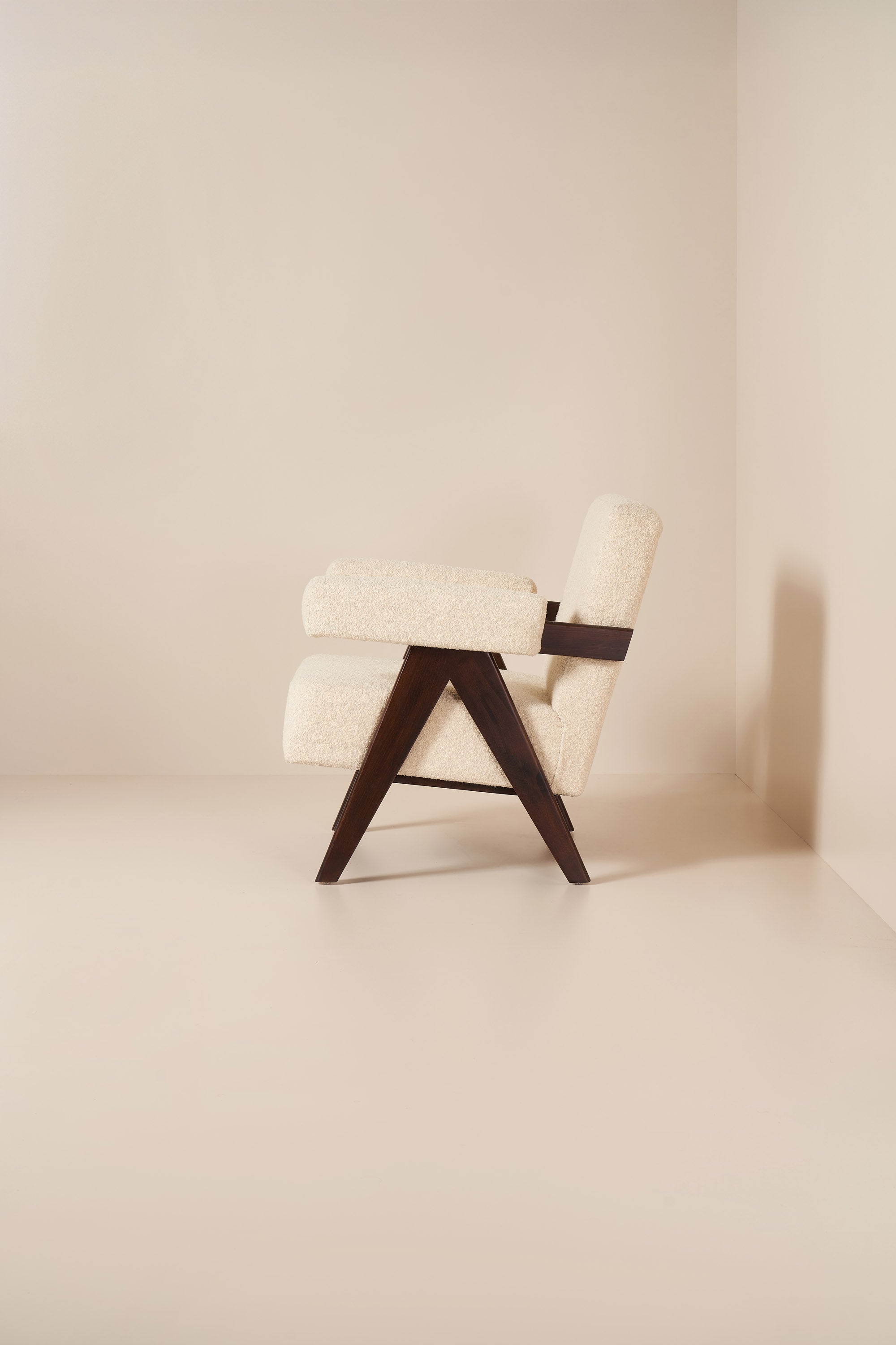 Modern chair with a wooden frame and white cushion in a minimalistic setting