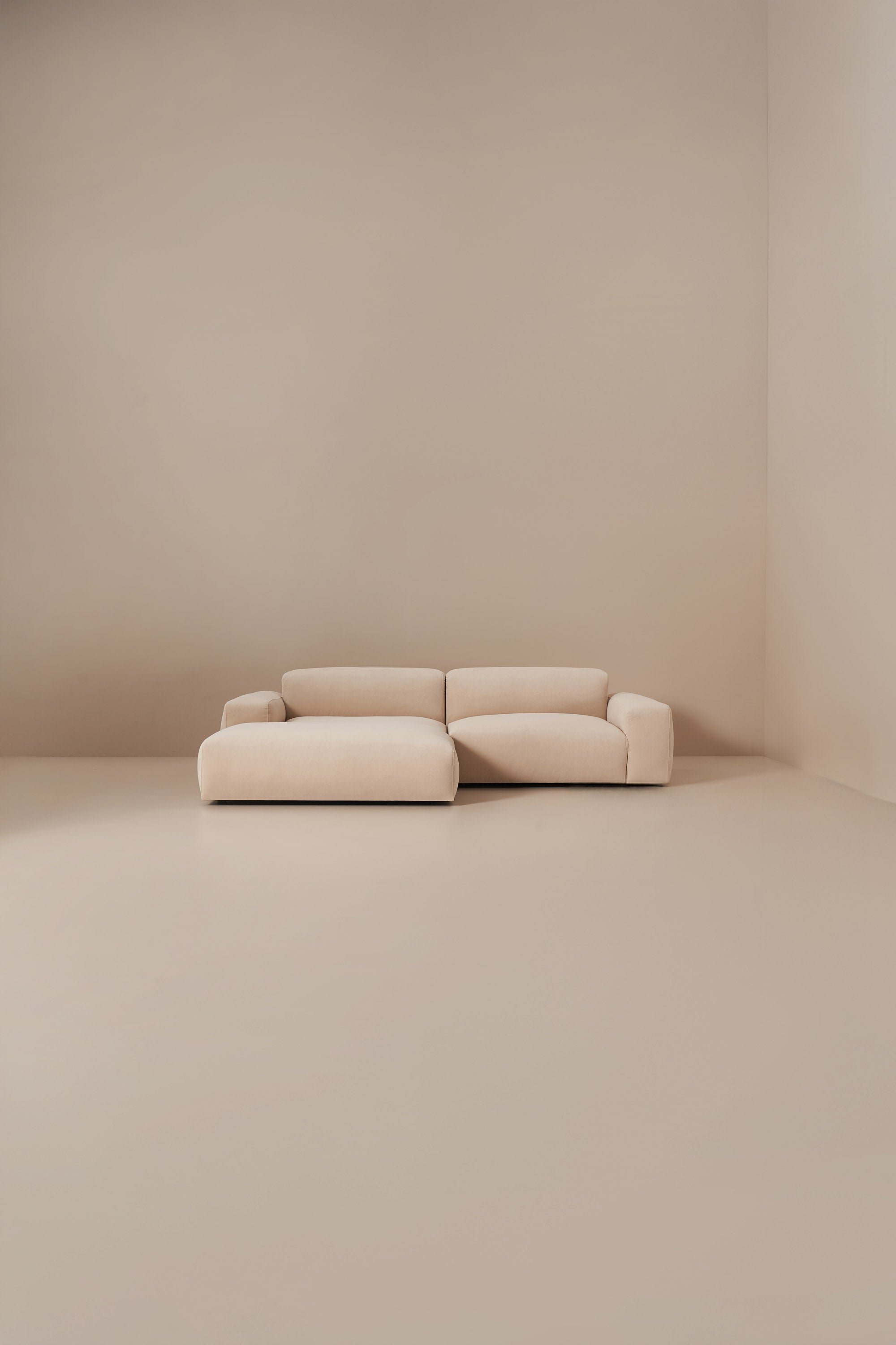 Beige sofa in a minimalistic room with beige walls and floor