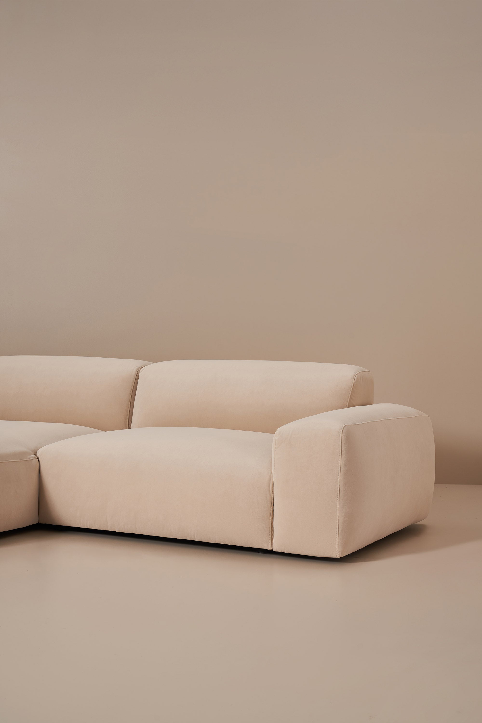 Beige sectional sofa against a beige wall