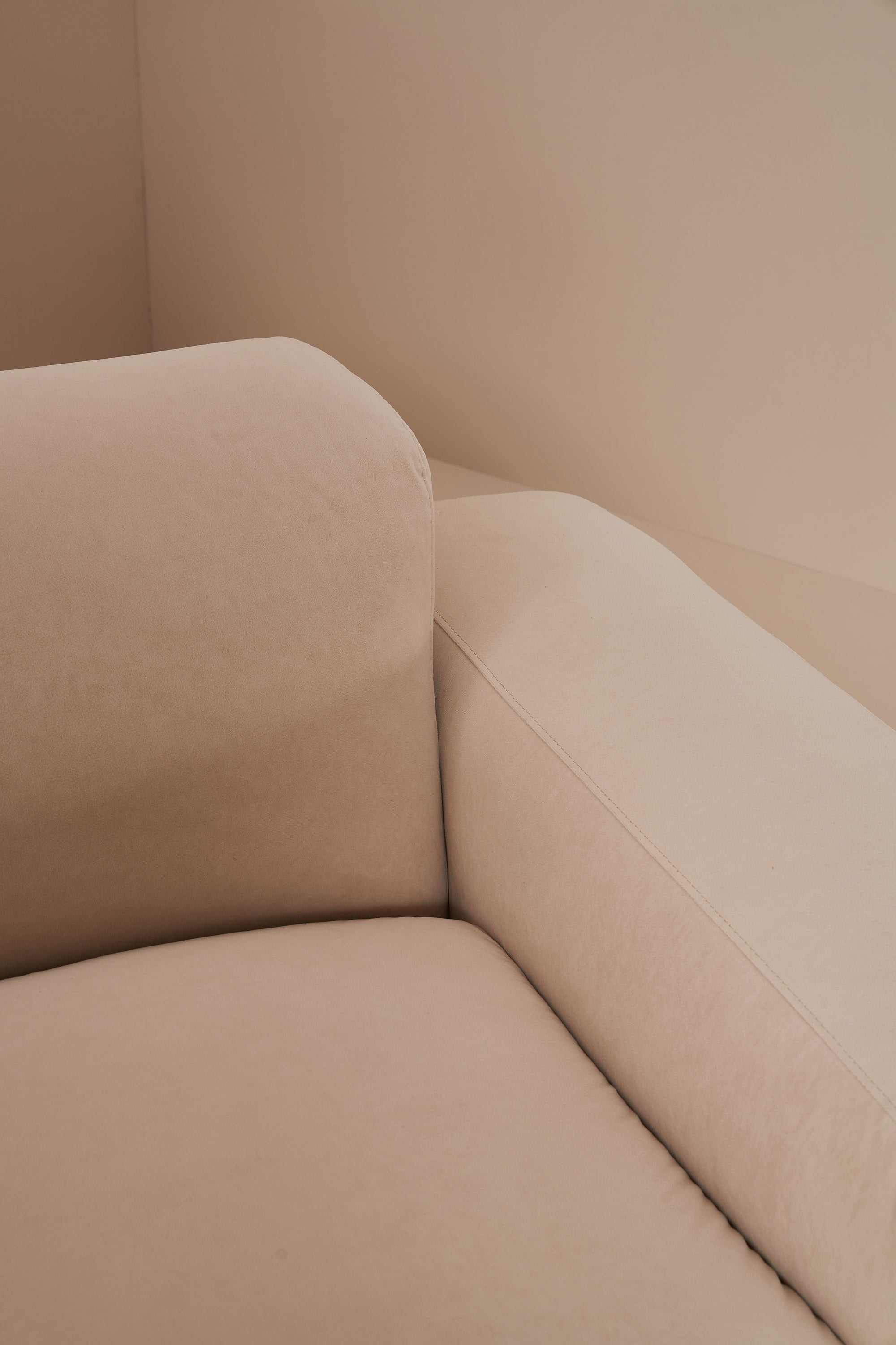 Beige corner of a sofa against a neutral wall