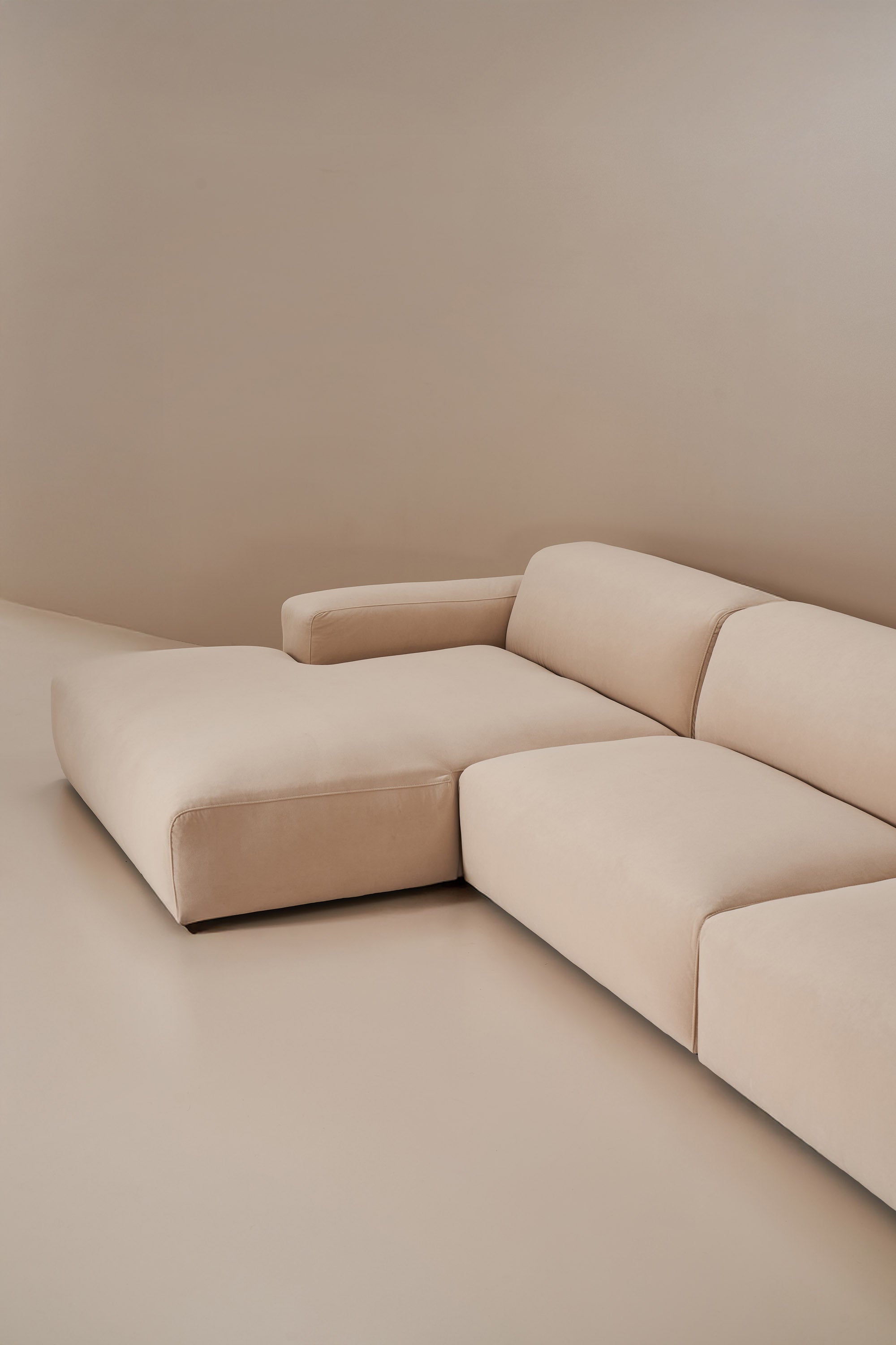Beige sectional sofa against a plain wall