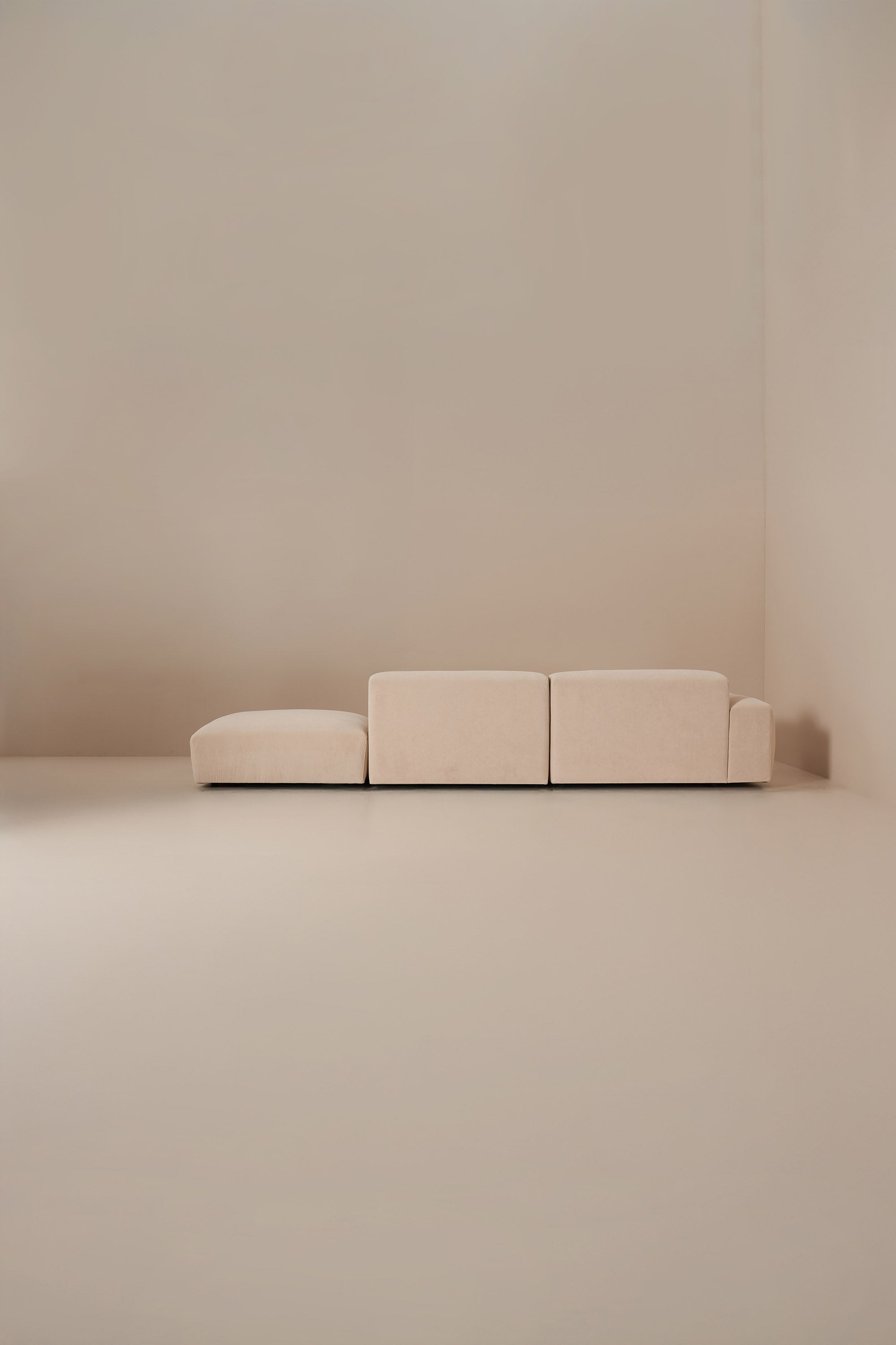 Minimalist beige modular sofa against a plain wall