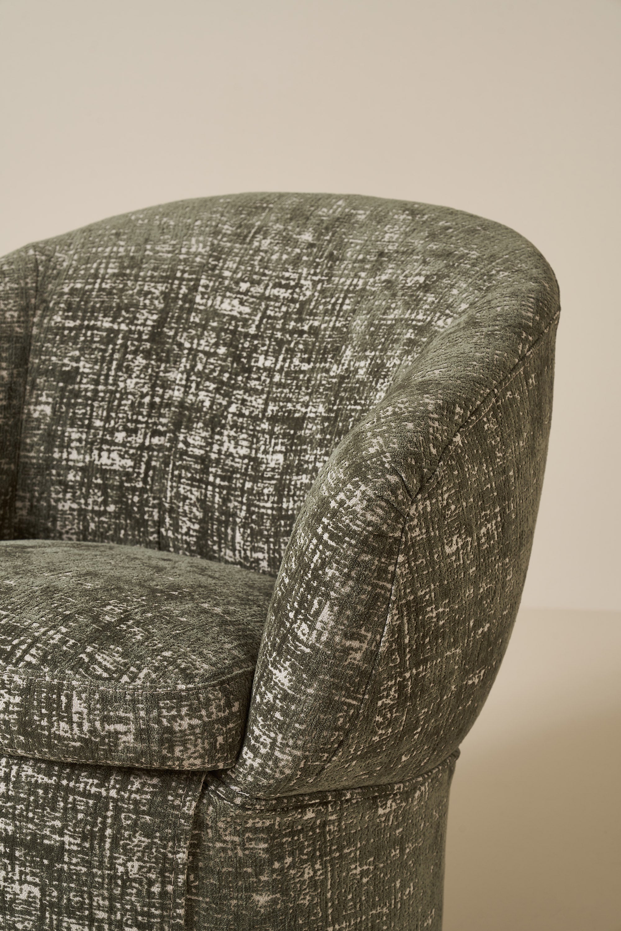 Close-up of a textured green chair against a beige background
