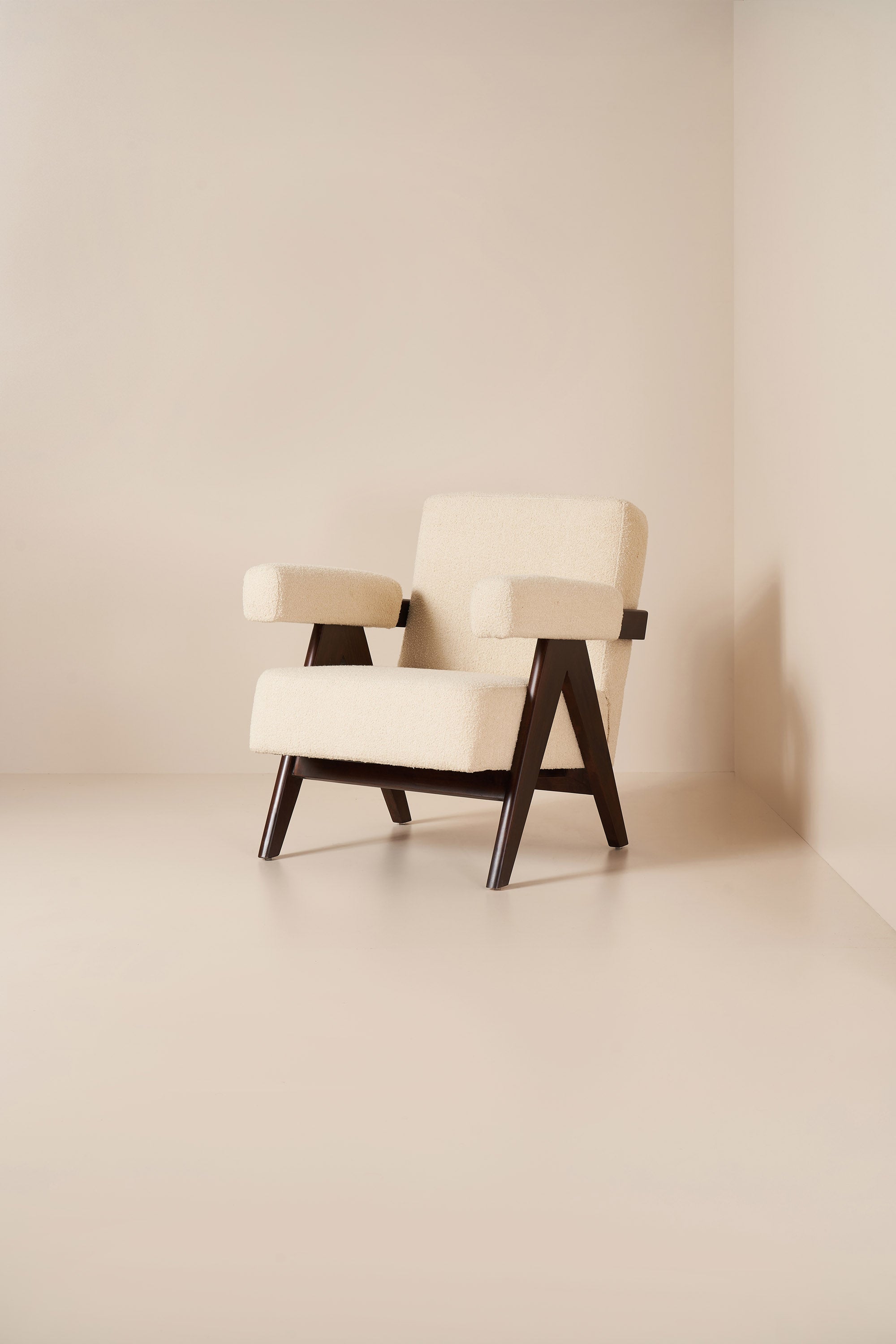 White armchair with wooden legs in a minimalistic room